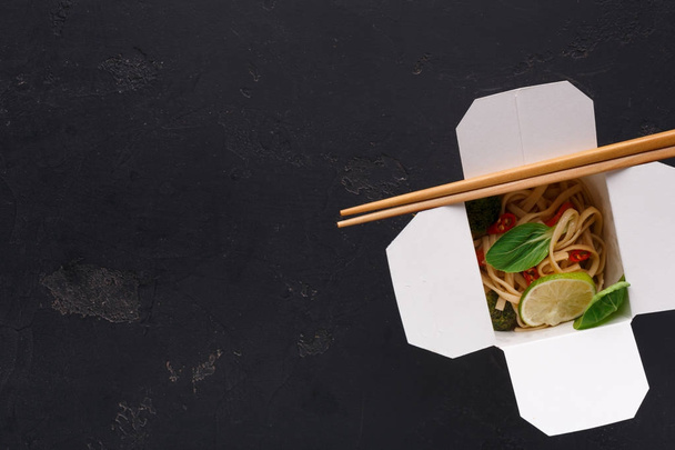 Comida asiática en caja de entrega sobre fondo gris
 - Foto, imagen