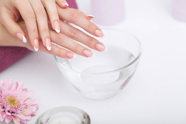 Beautiful manicure with orchid, candle and towel on the white wo - Fotoğraf, Görsel