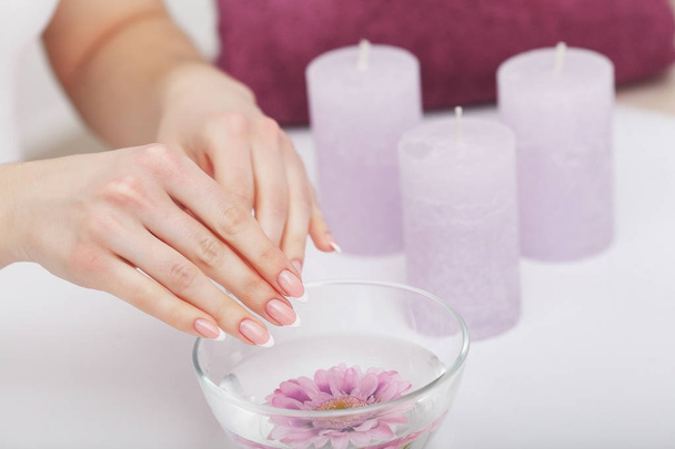 Beautiful manicure with orchid, candle and towel on the white wo - Foto, Imagen