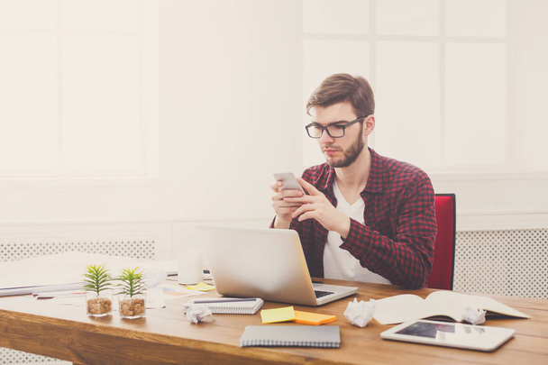 Jonge zakenman die werken met de laptop in moderne witte kantoor - Foto, afbeelding