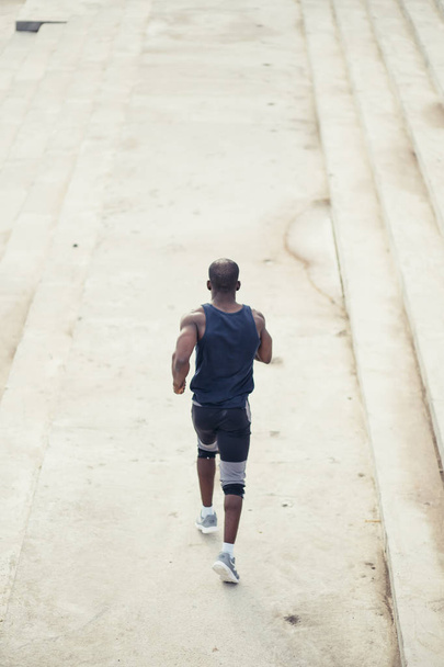 Vista posteriore uomo africano americano che corre sulla spiaggia
 - Foto, immagini