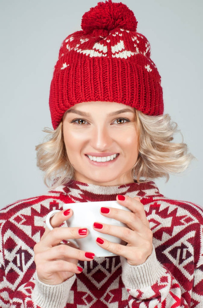 Christmas and New Year.  Woman in warm hat is holding a cup of coffee.  - Fotó, kép
