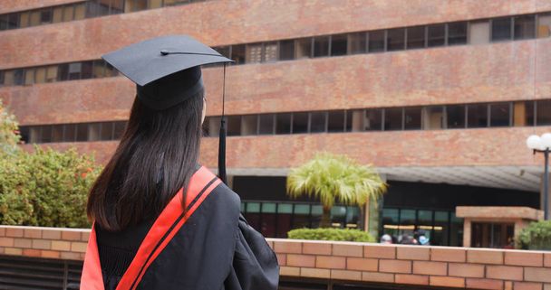 Volver de Mujer Asiática con vestido de graduación pensar en el futuro
 - Foto, imagen