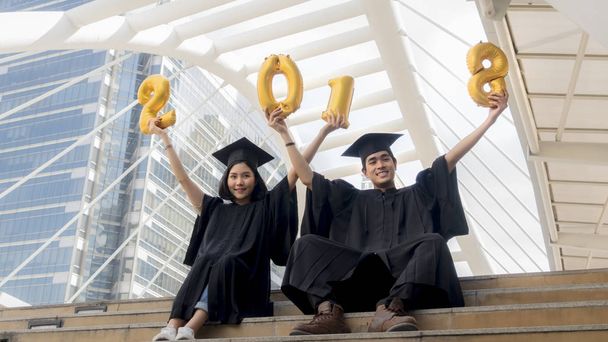 students in graduation suit sit and gold number balloons 2018 - Foto, Imagem
