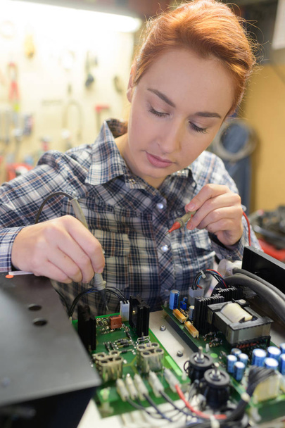 young woman technician repair electronics device - Foto, afbeelding