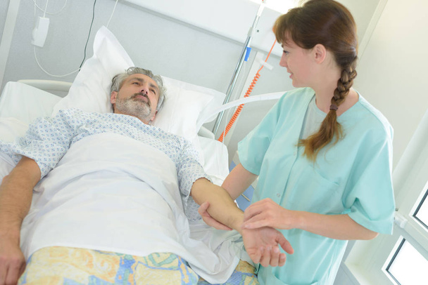 Nurse manually taking patient's pulse - Фото, изображение