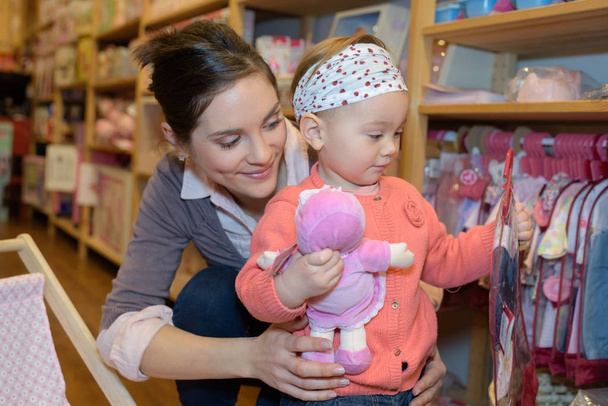 young mother her daughter shopping at the toy store - Zdjęcie, obraz