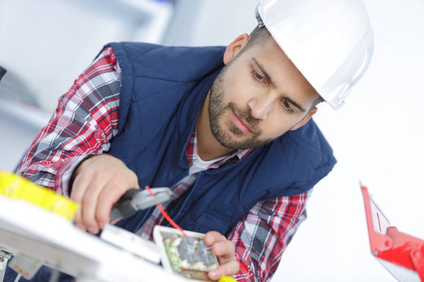 electrician cutting wire with pliers - Foto, Bild