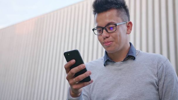 Молода людина використовує телефон зовні
 - Фото, зображення
