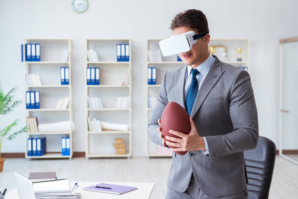 Businessman playing virtual reality football in office with VR g - Foto, afbeelding