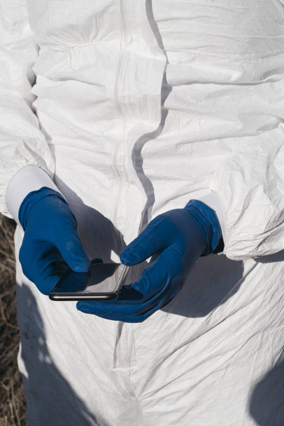 hands with blue gloves and smartphone - Foto, immagini