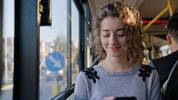 Une jeune femme utilisant un smartphone dans le bus - Photo, image