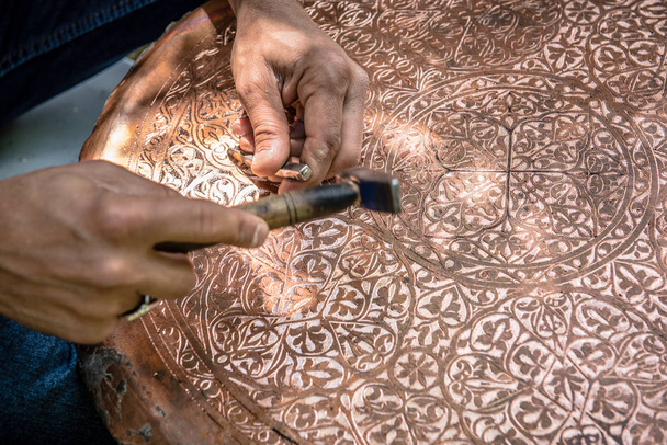 Artesanato sênior, tinsmith, trabalhando com martelo durante a mão carimbar ou gravura padrão de decoração em placa de metal. Mestre de cobre, mãos detalhe do artesão no trabalho
. - Foto, Imagem