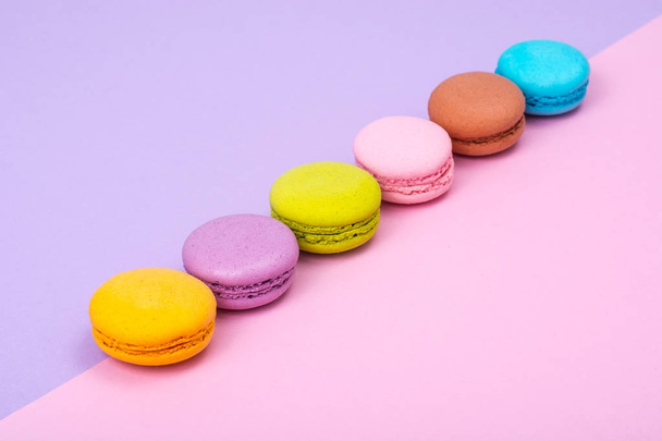 Small French macaroons on pastel background - Foto, Imagen