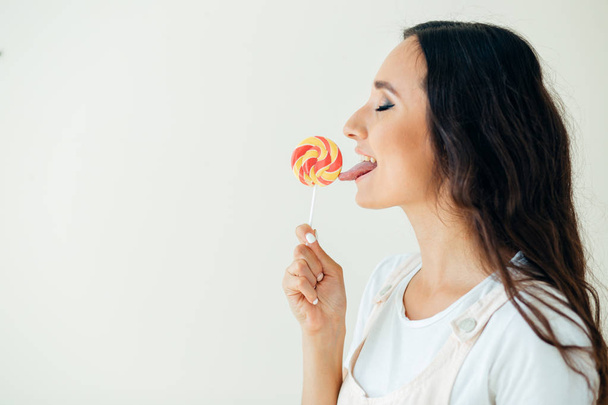 Fashion pretty sweet young woman enjoying a taste lollipop - Photo, Image