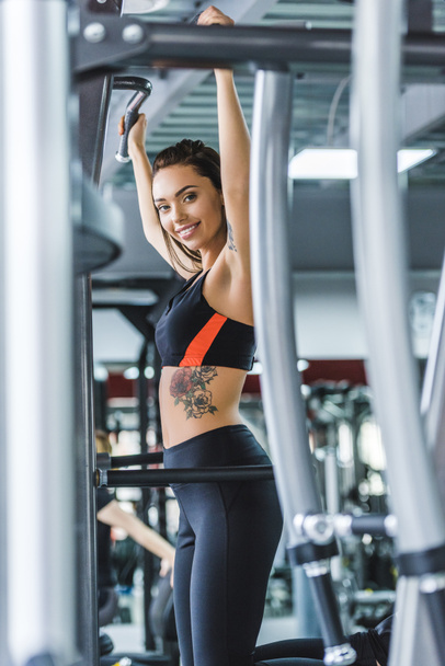 athletic young woman doing pull ups at gym - Fotoğraf, Görsel