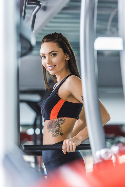 young beautiful woman working out on push up bars at gym - Foto, afbeelding