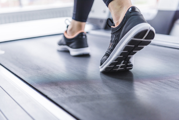 cropped shot of woman in jogging sneakers running on treadmill - Photo, Image
