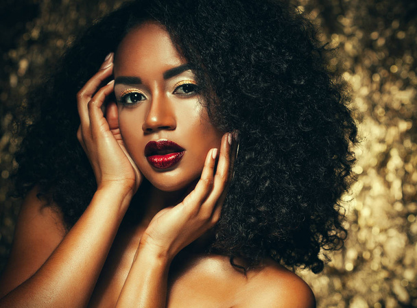 young elegant african american woman with afro hair. Glamour makeup. Golden Background. - Фото, зображення