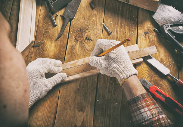 The carpenter works with wood on his workspace - Valokuva, kuva