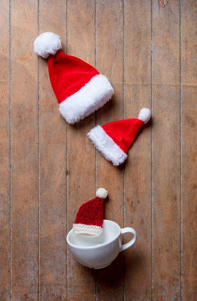 Copo branco e chapéus de Natal
 - Foto, Imagem