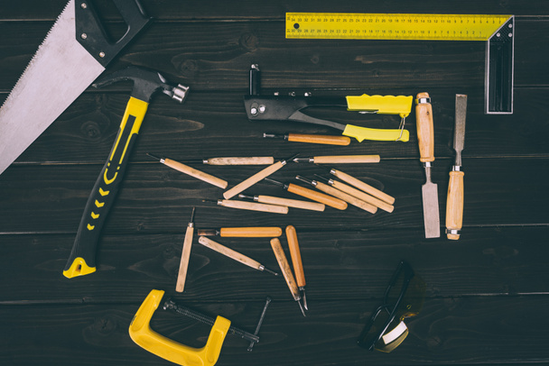 top view of various carpentry tools on dark wooden surface - Φωτογραφία, εικόνα