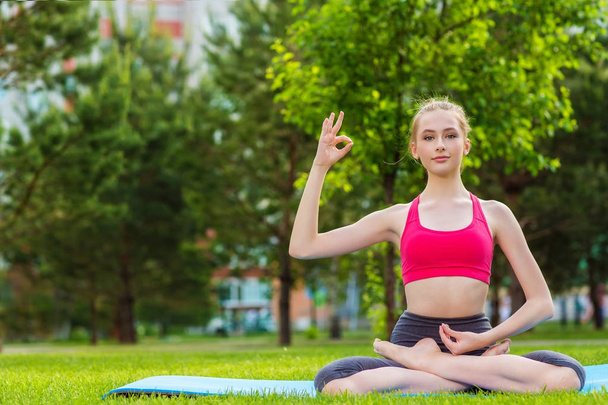young woman doing yoga exercise in park - Zdjęcie, obraz