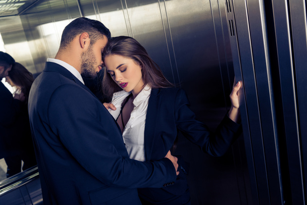 sensual business couple undressing in elevator - Foto, afbeelding