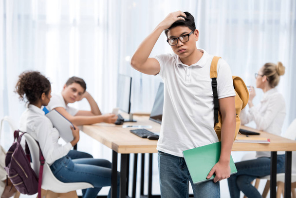 junge nachdenkliche asiatische Student Junge in Klassenzimmer mit Freunden - Foto, Bild