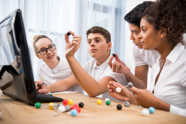 jeunes étudiants multiculturels choisissant un modèle moléculaire pour une leçon de science
 - Photo, image