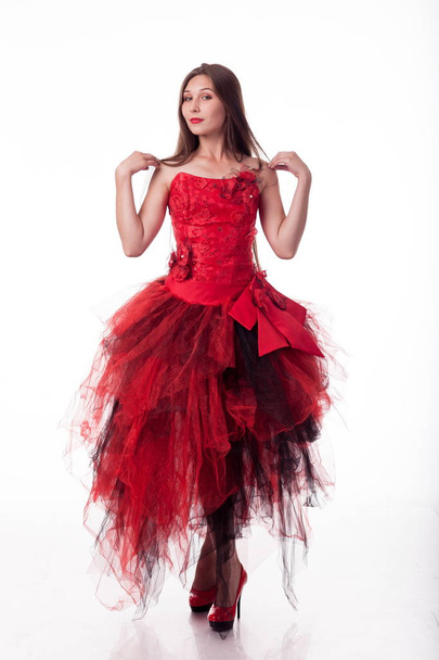 Charismatic girl in red dress dances and shows different emotions and poses  poses on camera on white background.  Beautiful young girl with long hair posing in the Studio. long brown hair. Shows different gestures.  - Fotografie, Obrázek