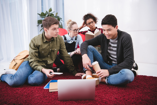adolescenti multiculturali che studiano con laptop e quaderni
 - Foto, immagini