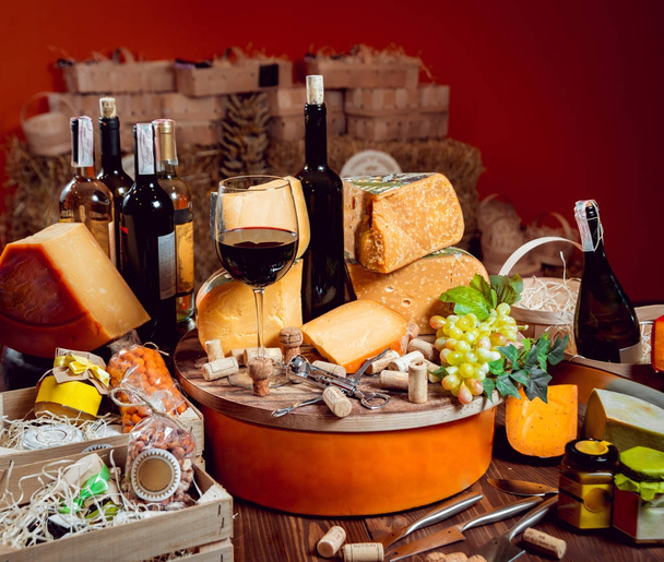 Beautiful and rich composition with assorted cheeses and wine with nuts and grape - Fotó, kép