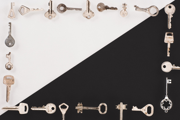 top view of different vintage keys frame over black and white background - Foto, imagen