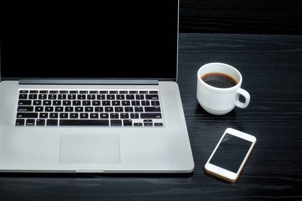 Dizüstü bilgisayar, bir fincan kahve ve siyah bir arka plan akıllı telefon açmak - Fotoğraf, Görsel