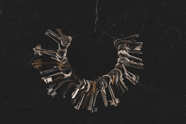 top view of bunch different keys on black table - Φωτογραφία, εικόνα