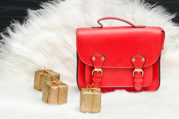 Bolsa roja y mini caja de regalo en piel blanca. Concepto de moda
 - Foto, imagen