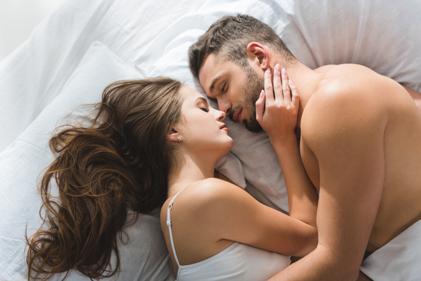 vista superior do jovem casal abraçando na cama de manhã
 - Foto, Imagem
