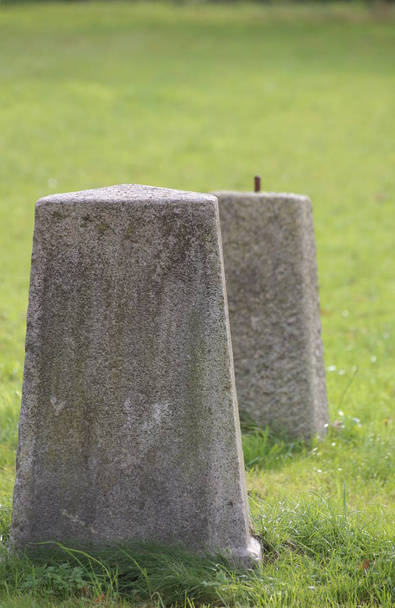 Obeliscos de hormigón de pie sobre un césped verde
 - Foto, Imagen