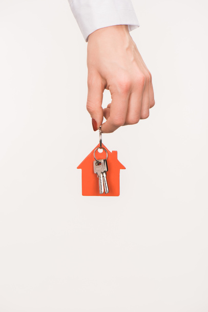 cropped image of female hand holding key from house isolated on white - Photo, Image