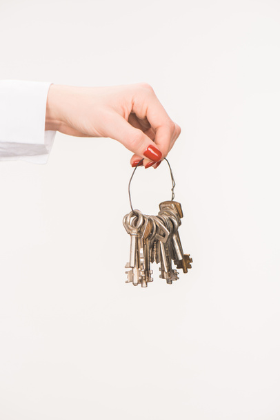 cropped image of female hand holding keys isolated on white - Fotó, kép