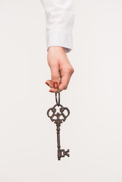 przycięte zdjęcie kobiece ręki trzymającej vintage klucz na białym tle - Zdjęcie, obraz