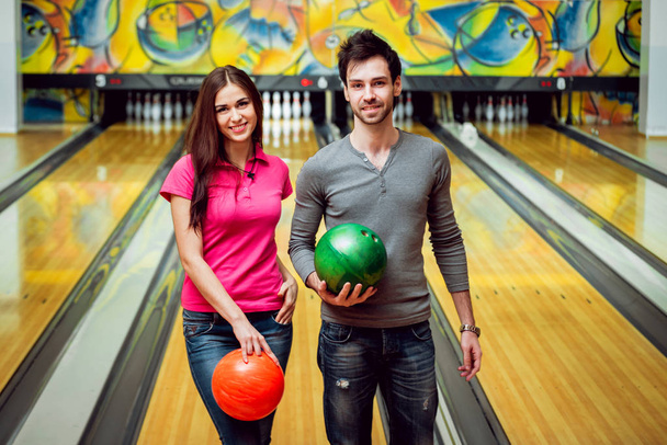 Beautiful girl and young man at the bowling alley with the ball - Valokuva, kuva