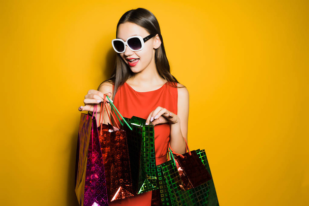 happy stylish girl in sunglasses went shopping on a black Friday - 写真・画像