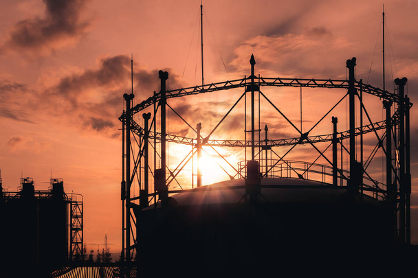 Gasomètre dans l'usine de l'industrie pétrochimique avec image de silhouette sur fond de lever de soleil ciel
 - Photo, image