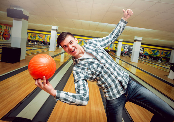 Happy young man at the bowling alley with ball - Foto, immagini