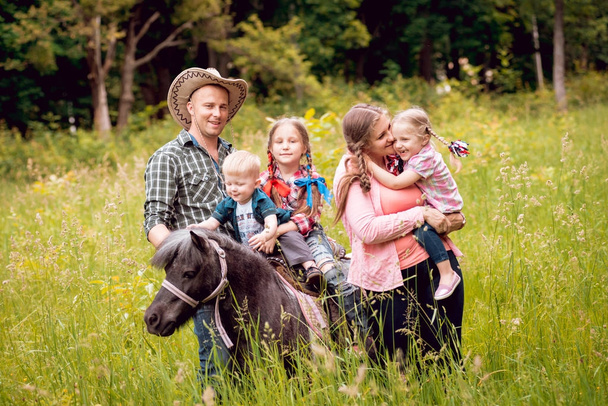 Cheerful family walks with pony horse in park - Photo, Image