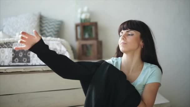 a woman dresses a sports blazer in her apartment, the lady is in the apartment - Materiał filmowy, wideo