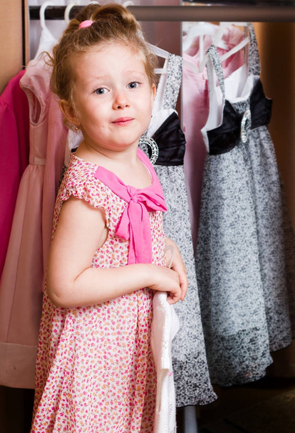  Joyful smiling girl with new dress in shop - Photo, Image