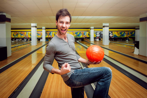 Young caucasian man having fun at the bowling club - Фото, зображення